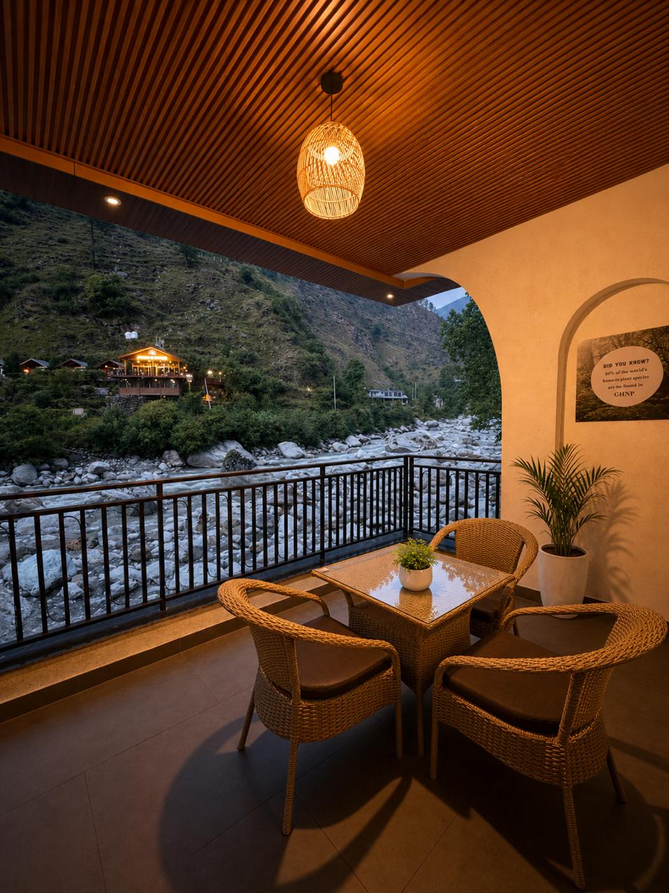 Private balcony at Tiraya Hotel with Tirthan River view and rattan seating, Himachal Pradesh
