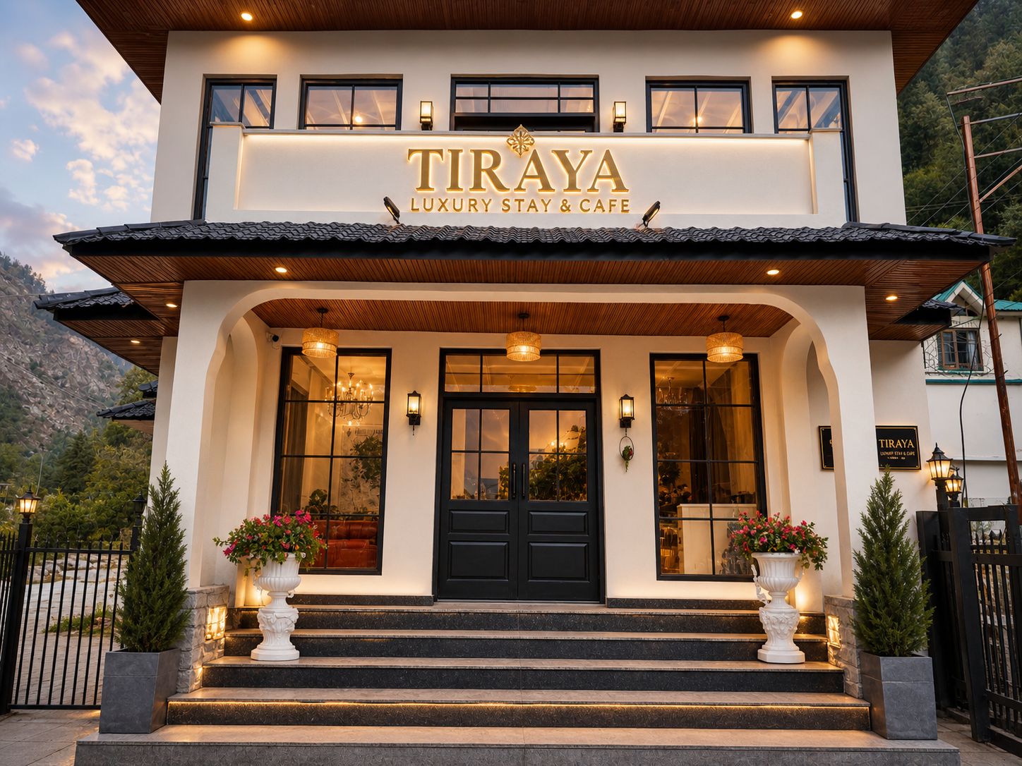 Tiraya Hotel grand entrance with TIRAYA signage, flower urns and mountain backdrop, Tirthan Valley