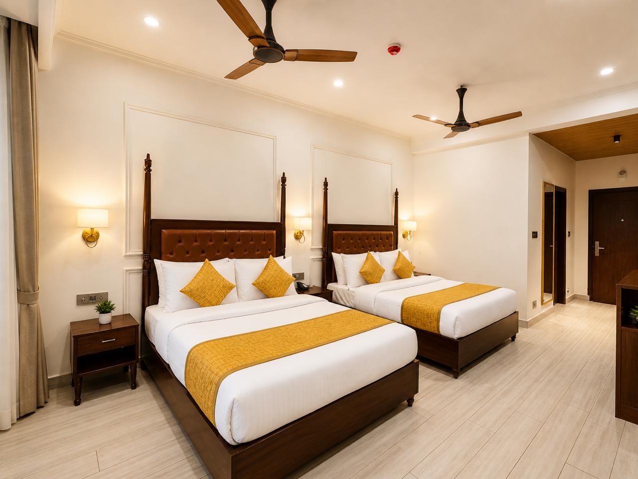 Family Room at Tiraya — two king four-poster beds with golden accents, spacious layout, private balcony
